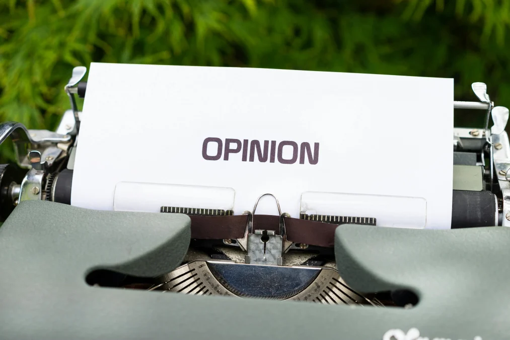 Close-up of a typewriter with paper showing the word Opinion representing community feedback and polls