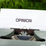Close-up of a typewriter with paper showing the word Opinion representing community feedback and polls