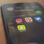 Smartphone displaying social media apps including Instagram and Snapchat representing community features