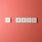 Keyboard letter tiles spelling email on coral background representing email capture and list building
