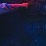 Hand interacting with glowing circuit board representing AI integration in community platforms